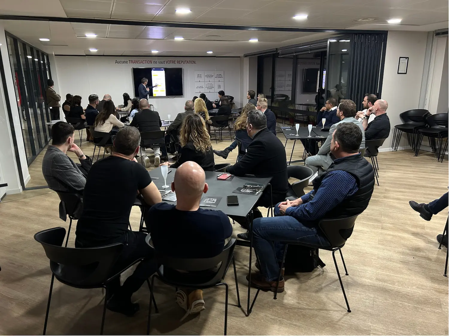 Auditoire attentif autour d'une table lors d'une intervention au club